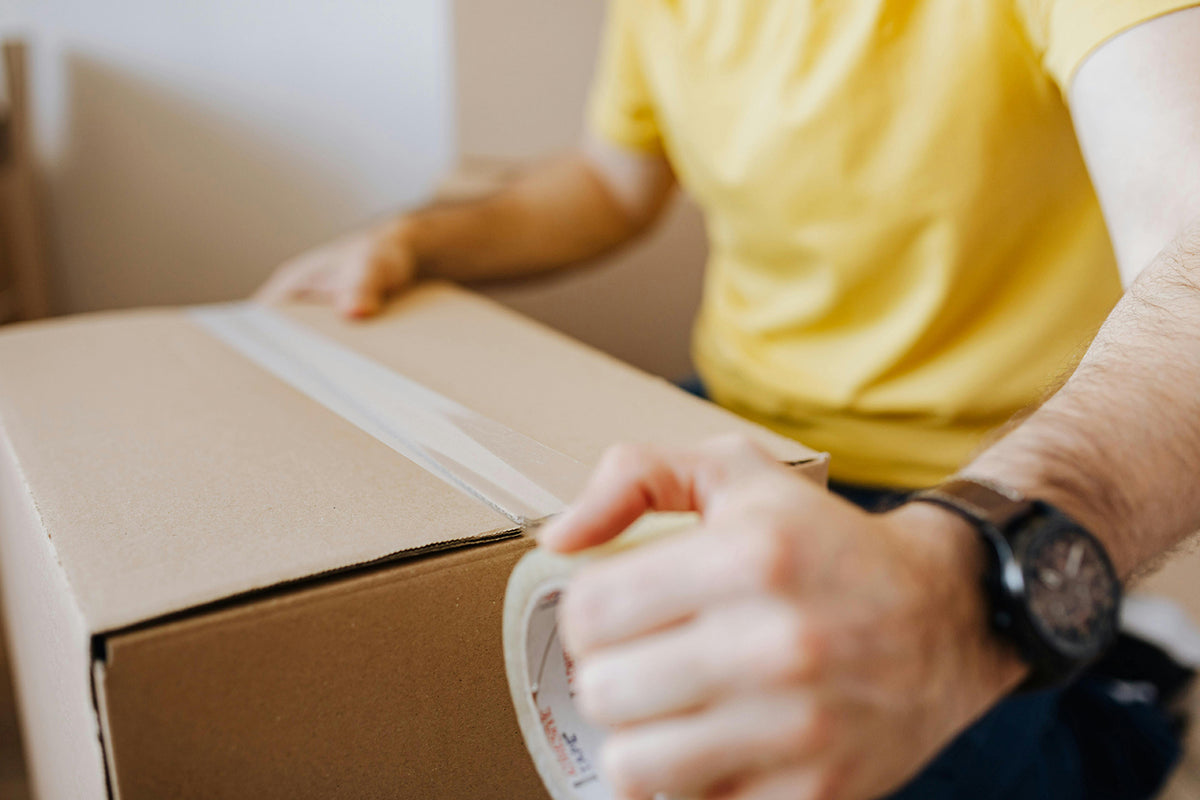 Man Taping Box of Goods